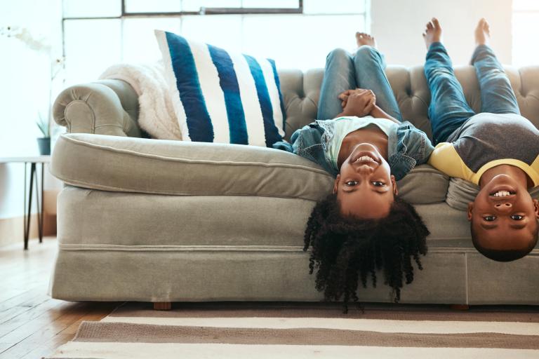 Two foster children playing on a sofa