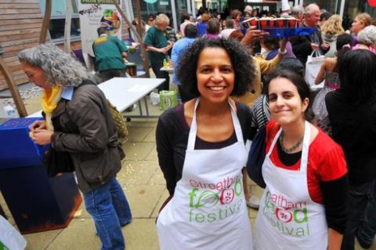 Two women with 'Streatham food festival' aprons on