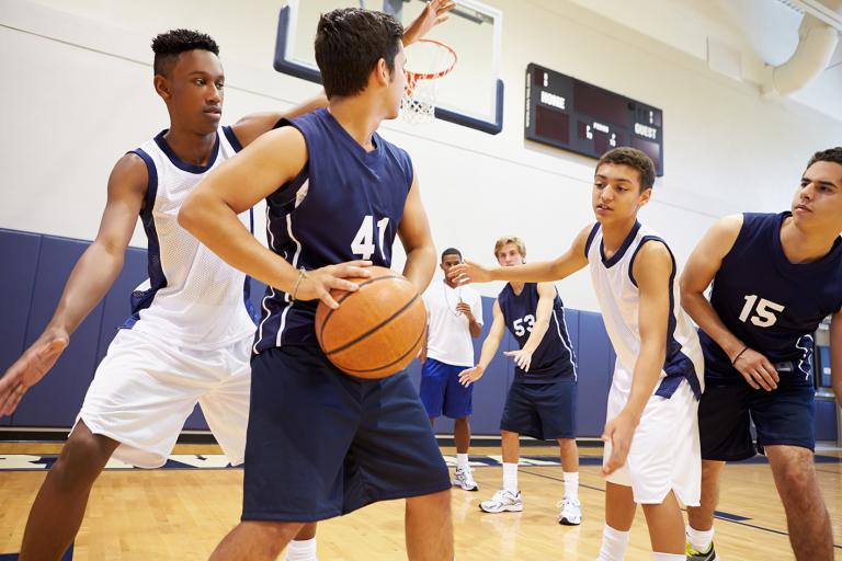 teenage boys of mixed ethnicities playing basketball
