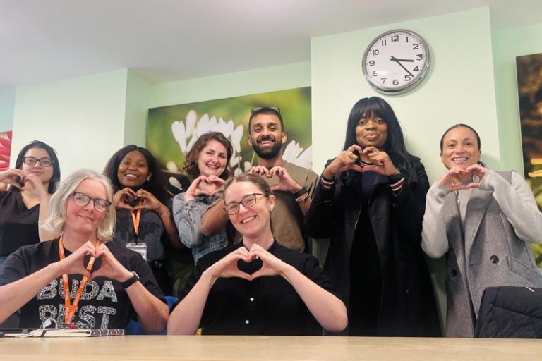 Team of people with hands together making a heart shape