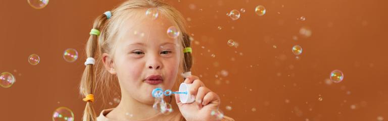 Happy girl blowing bubbles