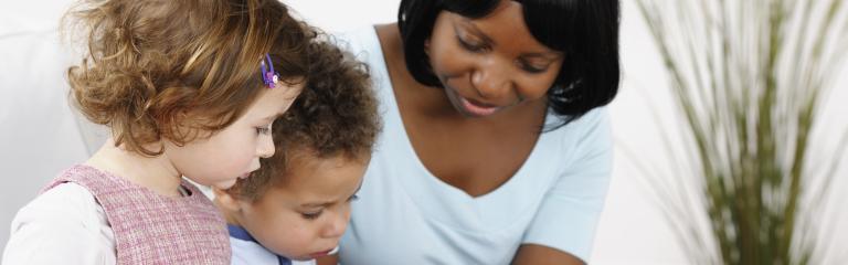 Woman with two children playing on tablet