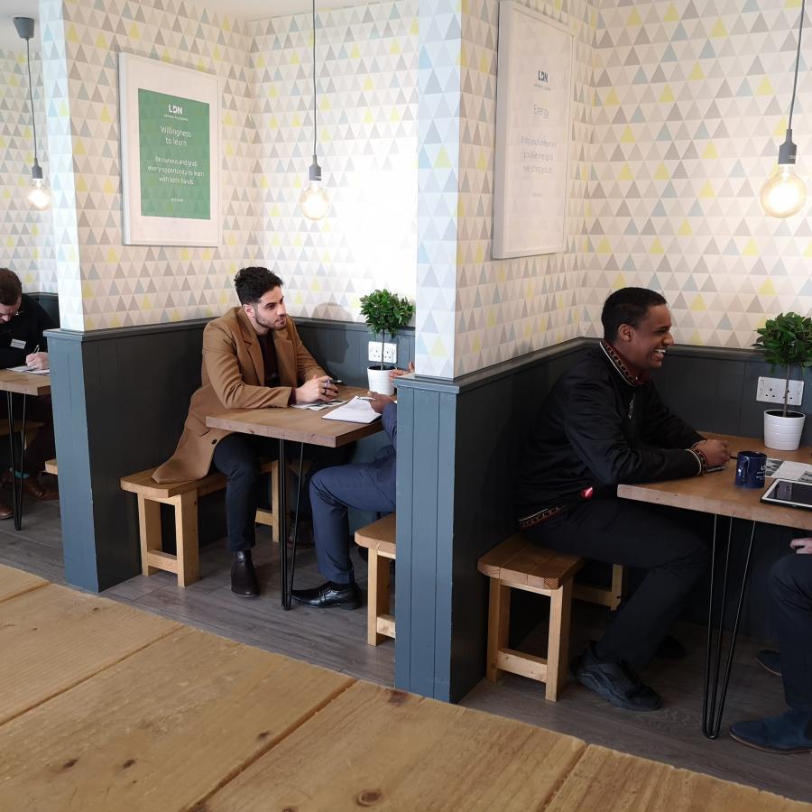People sitting talking in booths, opposite each other