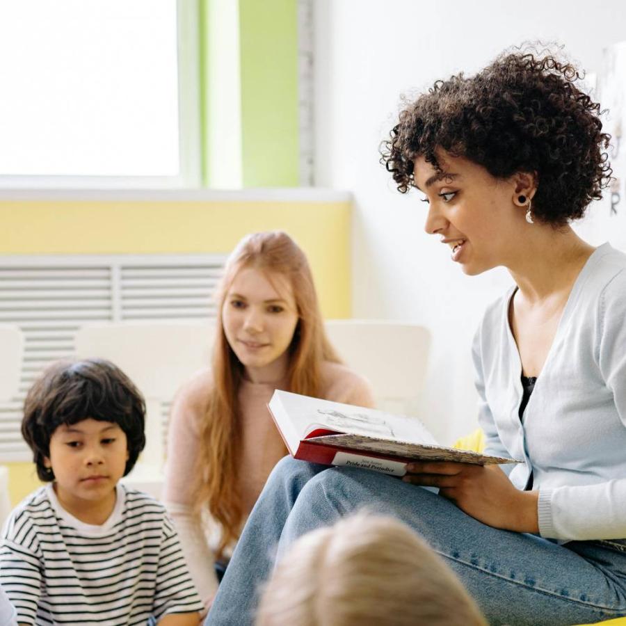 a lady reading a book to a child