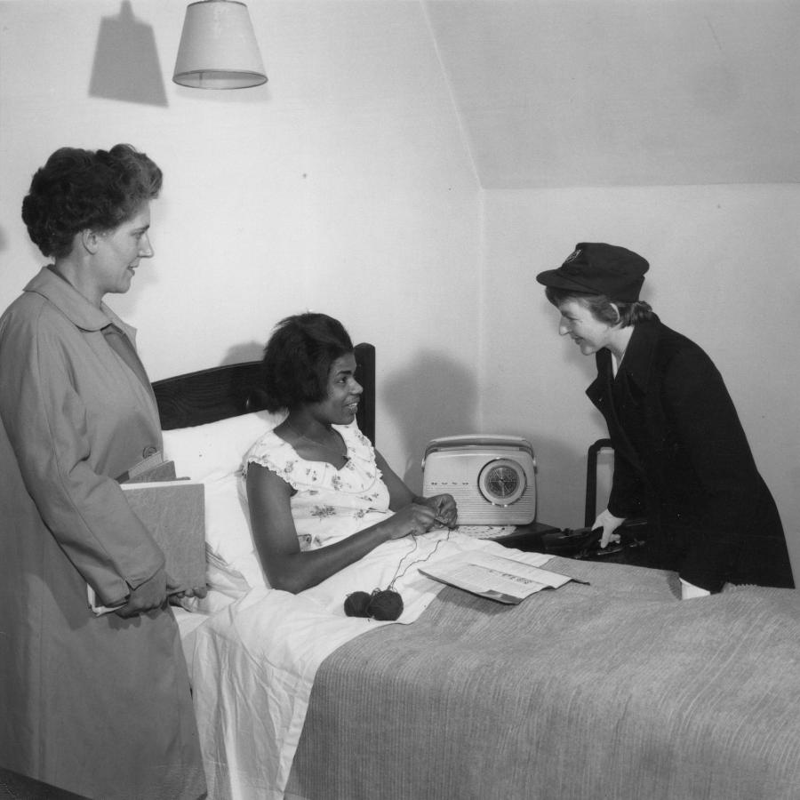 A sick lady with two nurses on her side