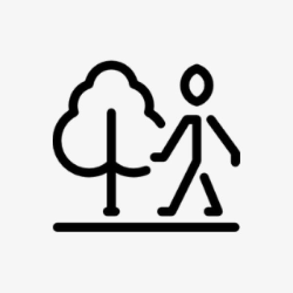 figure walking along a street with tree in background